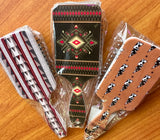 Packaged hairbrushes with geometric and animal pattern designs on a wooden surface