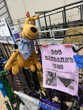 Scooby doo stuffed animal wearing an over the collar dog bandana with cartoon zebras, next to a pink sign