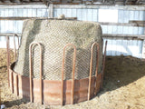 Rust colored feeder with a full round bale with an EZ Feeder hay net kit 